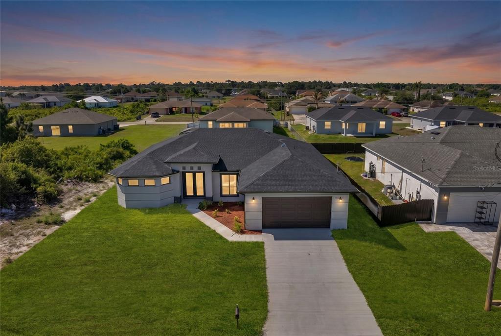 An aerial view of a single-story suburban house with a dark roof and driveway — 2915 23RD STREET SW, LEHIGH ACRES, FL