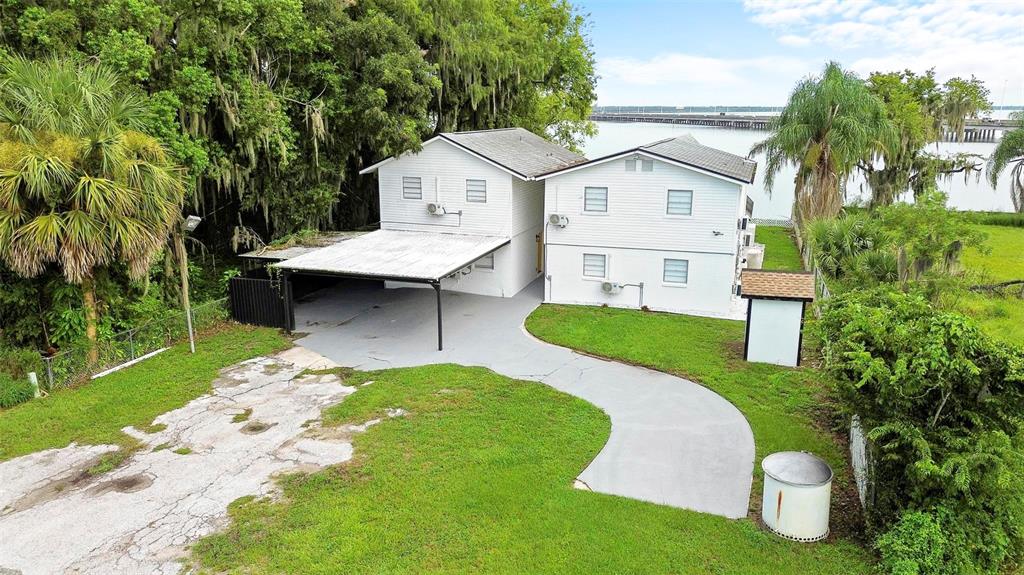 An aerial view of a two-story white house with a carport and a concrete driveway — 1824 LAKE STREET, OVIEDO, FL