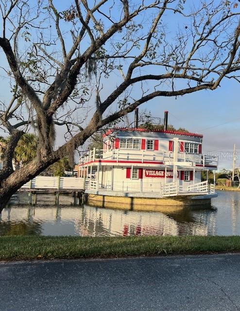 A white and red paddle-style boat sits on a calm body of water — 6039 VILLAGE CIRCLE BLDG C, ORLANDO, FL