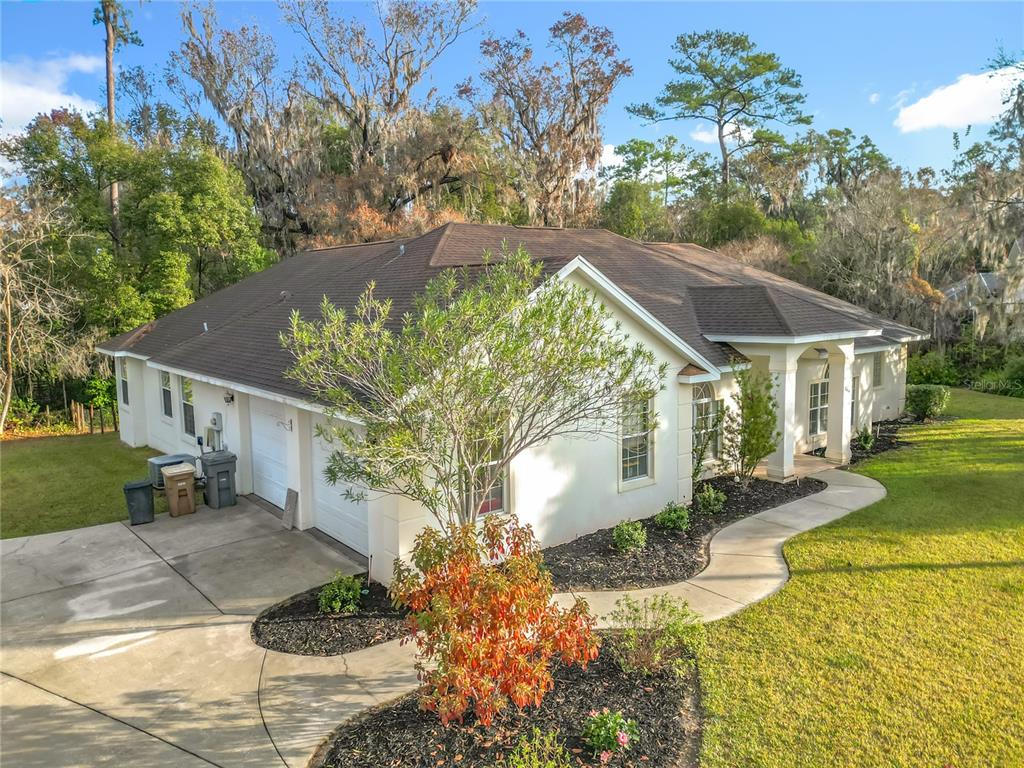 An exterior view of a single-story house with a two-car garage and landscaped yard — 2614 SE 25TH COURT, OCALA, FL