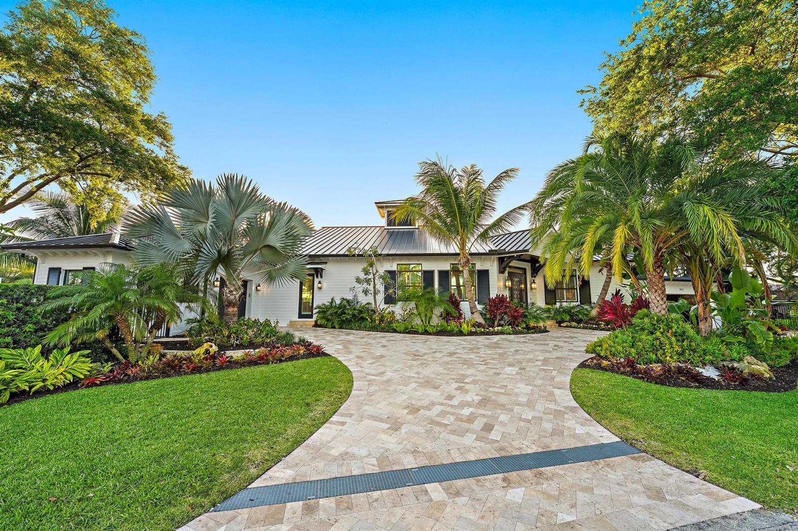 A white house with a metal roof and a paved driveway surrounded by tropical landscaping — 942 Pompano Drive, Jupiter FL 33458, JUPITER, FL