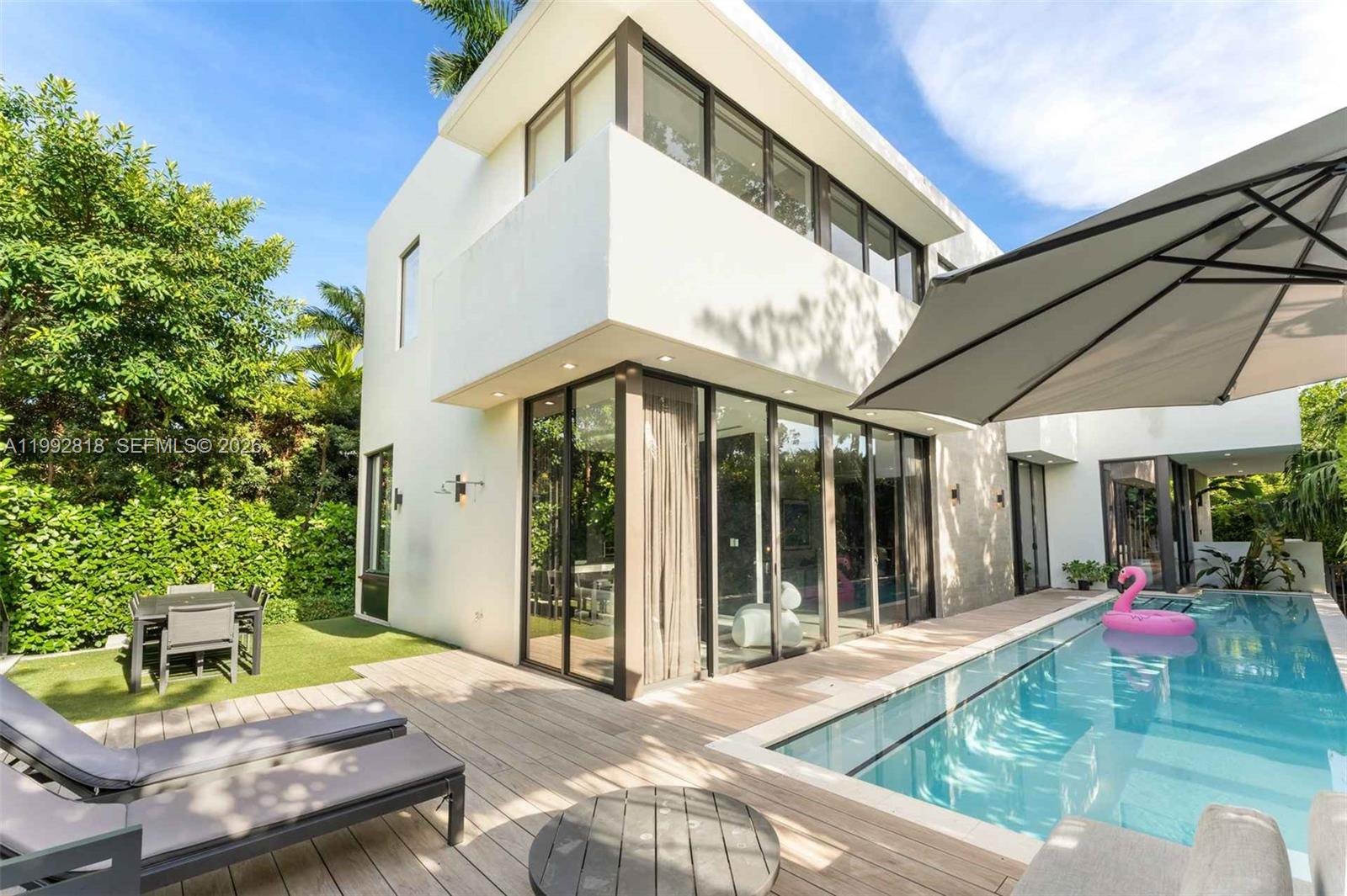 A modern two-story house with a swimming pool, wooden deck, and outdoor dining area — 121 2nd Dilido Ter. Share A, Miami Beach FL 33139, MIAMI BEACH, FL