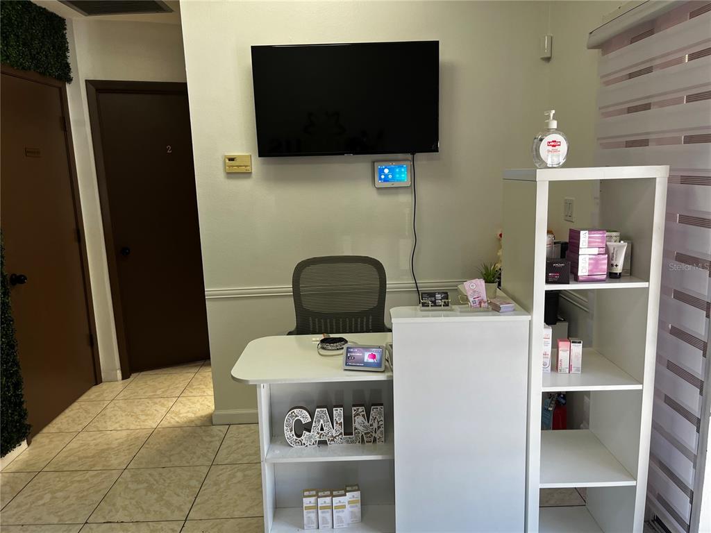 A reception desk with a sign reading "CALM" sits in a room with tiled floors — 318 N JOHN YOUNG PARKWAY UNIT 103, KISSIMMEE, FL