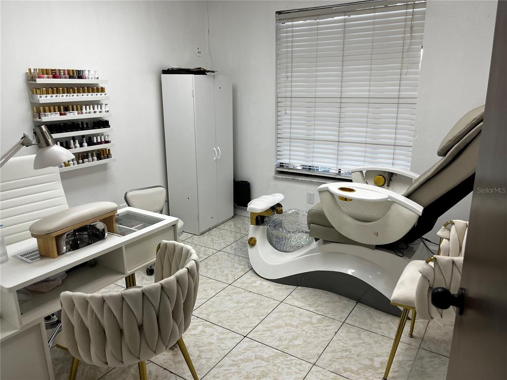 A nail salon room features a manicure station, a pedicure chair, and wall-mounted polish racks — 318 N JOHN YOUNG PARKWAY UNIT 103, KISSIMMEE, FL