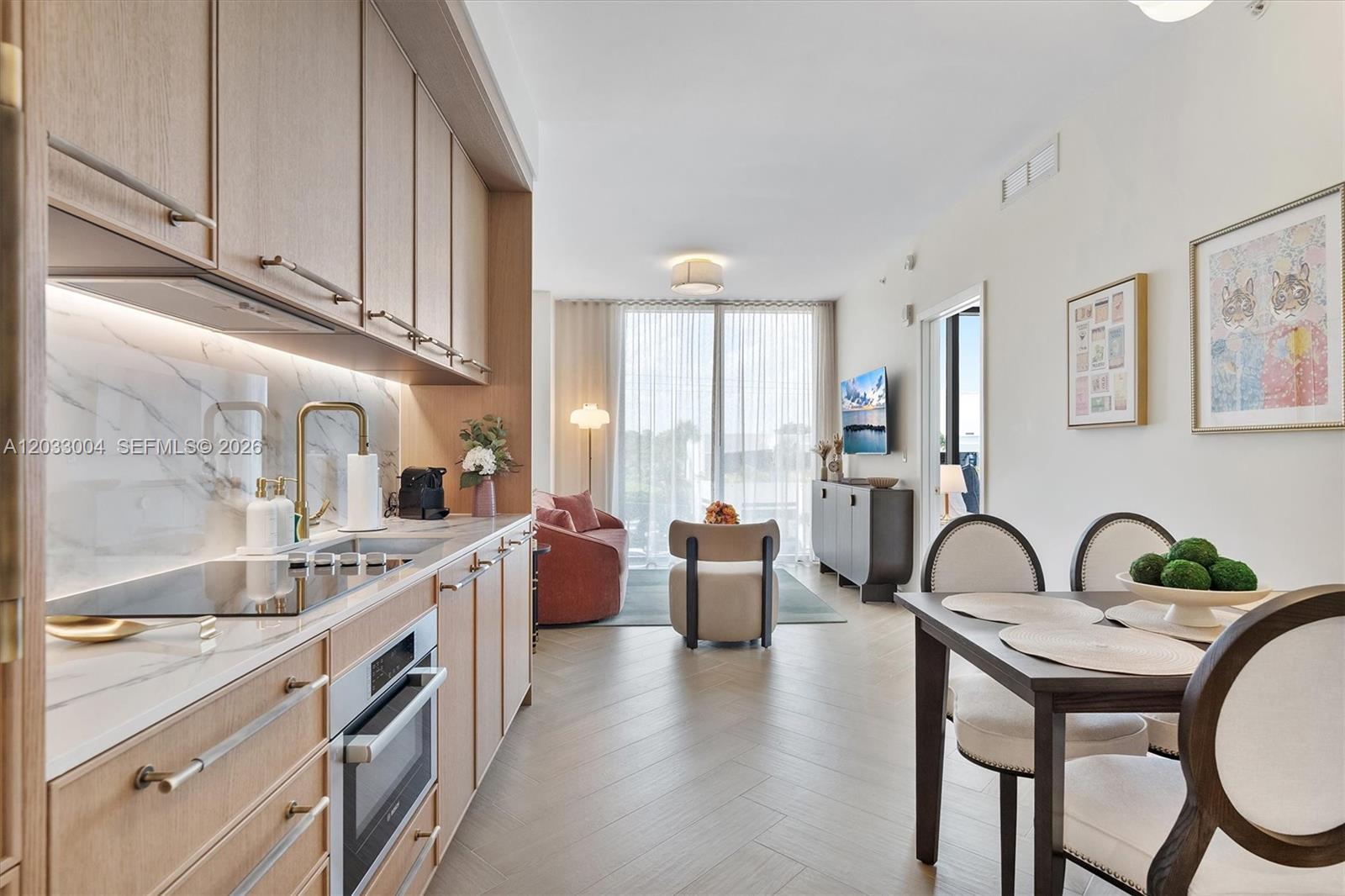 A modern kitchen and dining area with light wood cabinetry and herringbone flooring — 2700 NW 2nd Ave # 230, Miami FL 33127, MIAMI, FL