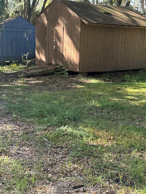 A brown wooden shed with a ramp stands in a grassy yard near another shed — 2101 STATE ROAD 50, GROVELAND, FL