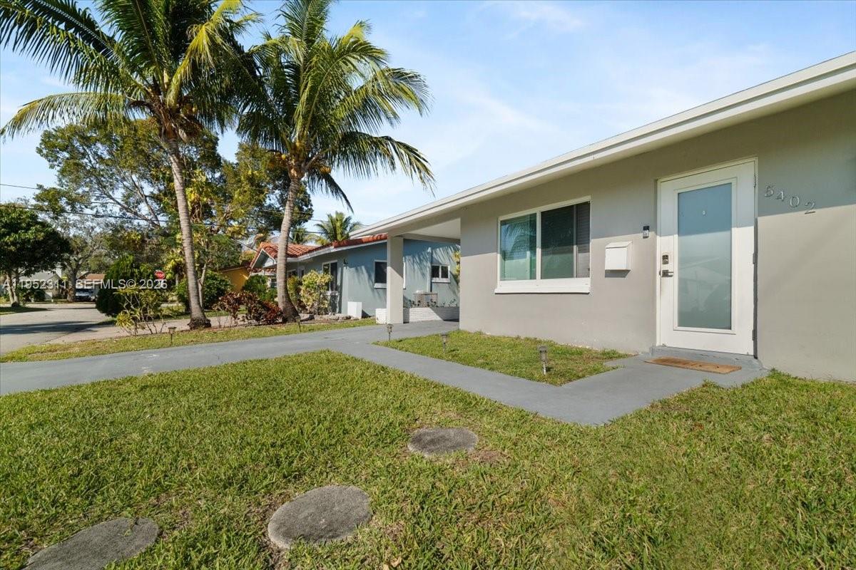 A single-story house with a gray exterior, a white front door, and a palm tree — 5402 NW 25th Ter, Tamarac FL 33309, TAMARAC, FL