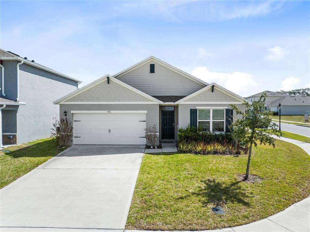 A single-story house with a gray stucco exterior, a two-car garage, and a front lawn — 452 BARONESS WAY, DELAND, FL