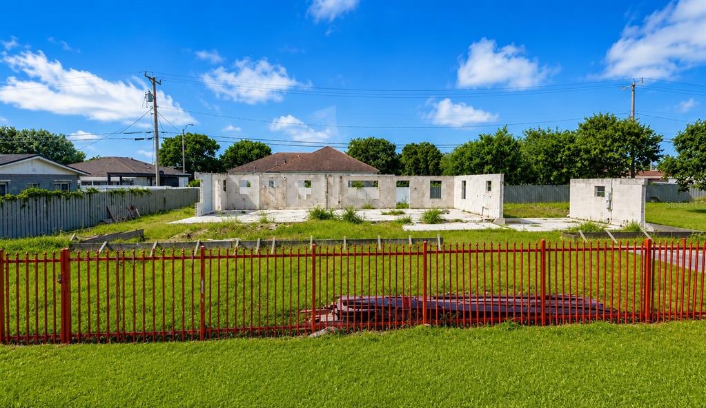 A fenced lot contains the concrete block walls of a house under construction — 21710 SW 111TH AVENUE, MIAMI, FL