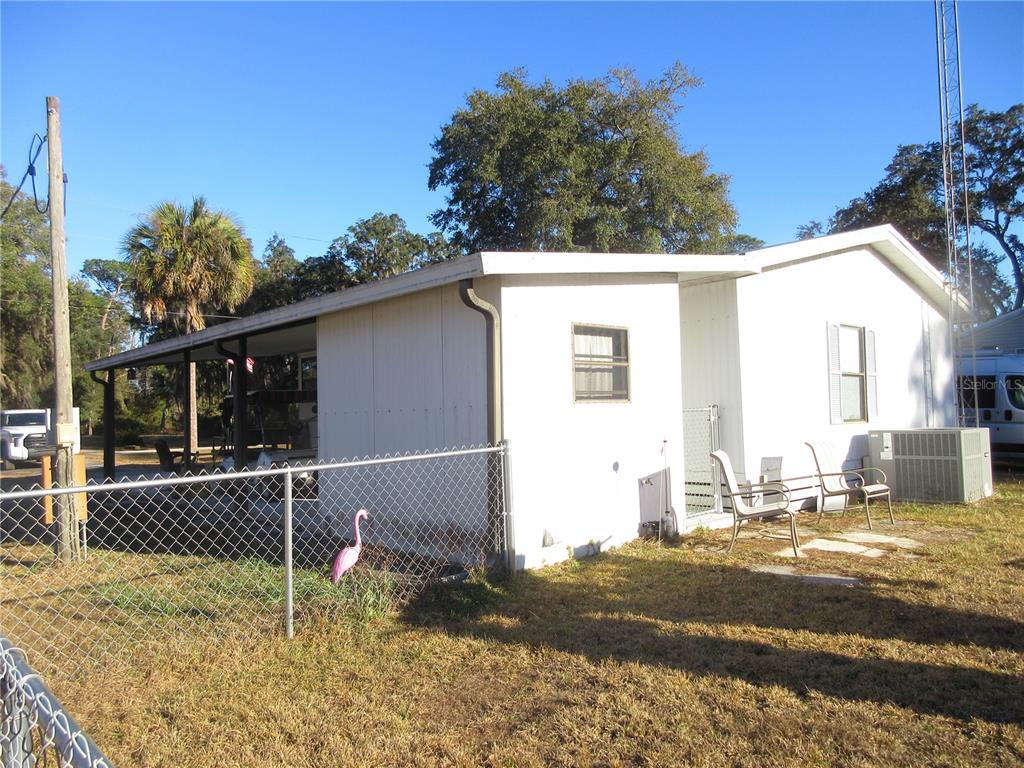A white mobile home with a covered porch and a chain-link fence in the yard — 1984 SE 171ST COURT, SILVER SPRINGS, FL