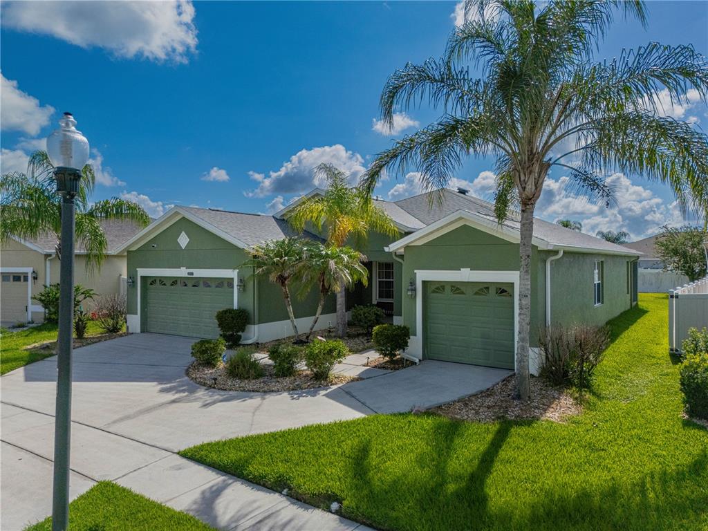 A green, single-story suburban house features two garage doors, a palm tree, and a driveway — 2317 CROSSTON CIRCLE, ORLANDO, FL