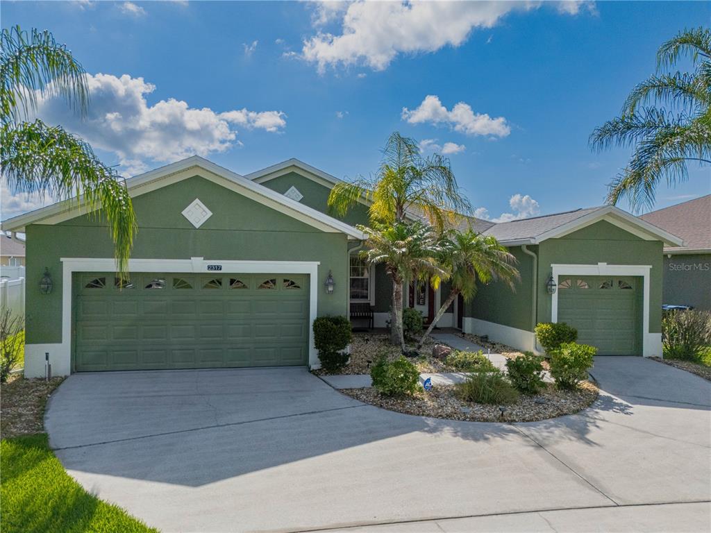 A green, single-story house with a two-car garage and a palm tree in the yard — 2317 CROSSTON CIRCLE, ORLANDO, FL