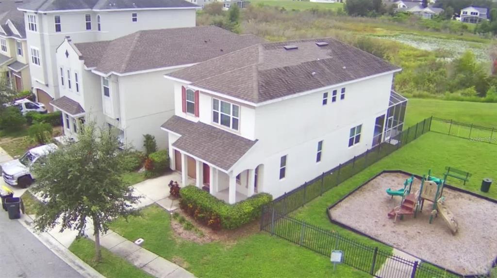 An aerial view shows a two-story house with a fenced backyard containing a playground — 193 ABERDEEN STREET, DAVENPORT, FL