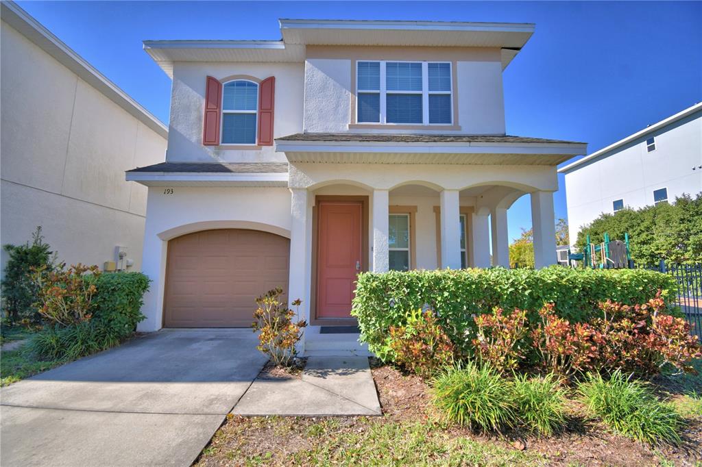 A two-story house with a garage, a peach-colored front door, and a manicured hedge — 193 ABERDEEN STREET, DAVENPORT, FL