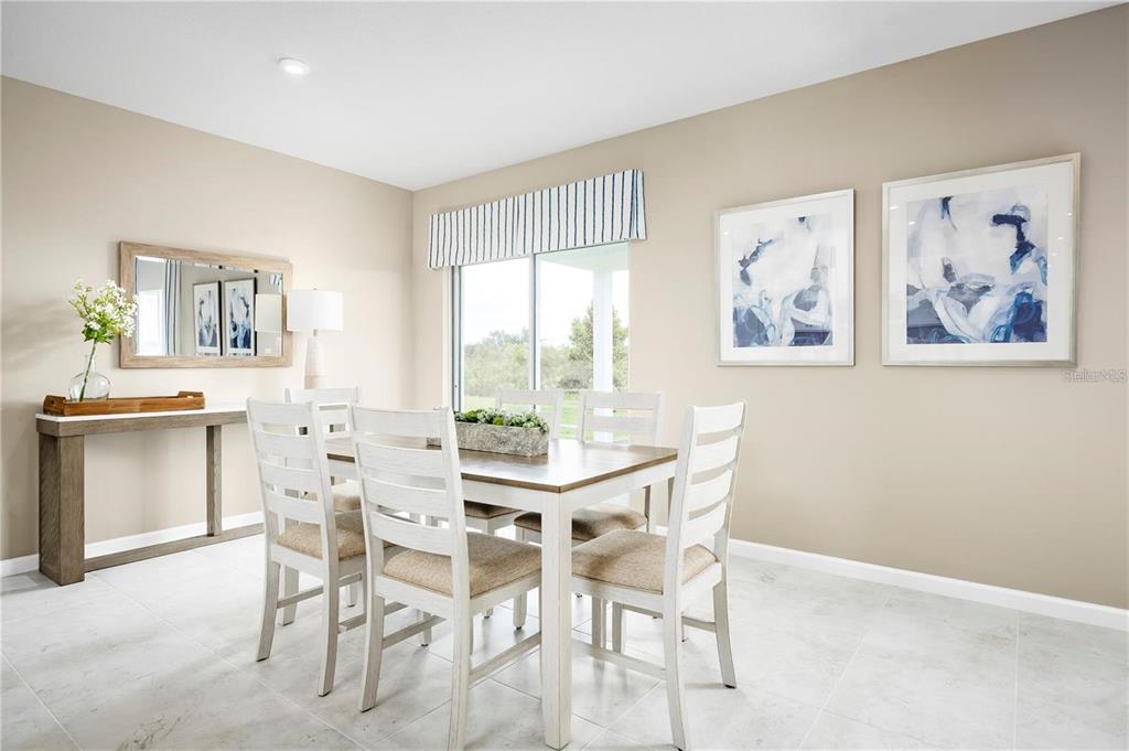 A dining room with a white table, six chairs, a console table, and wall art — 2744 GINGER LANE, HAINES CITY, FL