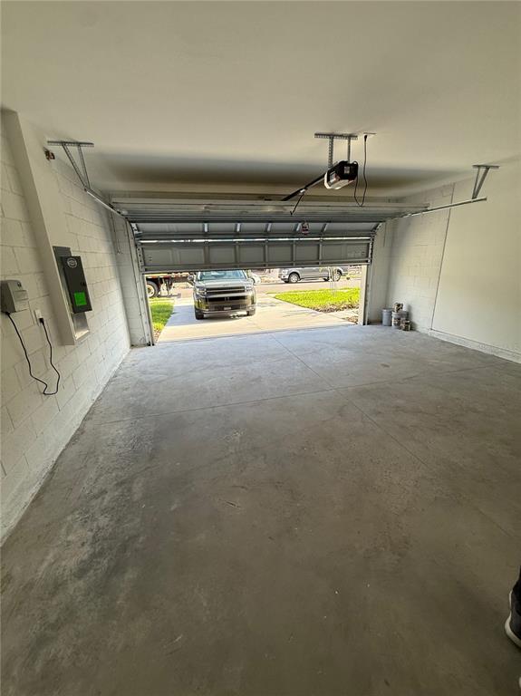 An empty residential garage with a concrete floor and an open overhead door — 6224 BOTTICELLA BOULEVARD, WINTER HAVEN, FL