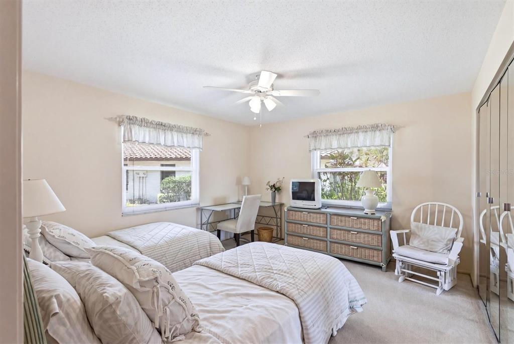 A bedroom features two twin beds, a desk, a dresser with a television, and a rocker — 5451 GOLF POINTE DRIVE UNIT V-225, SARASOTA, FL