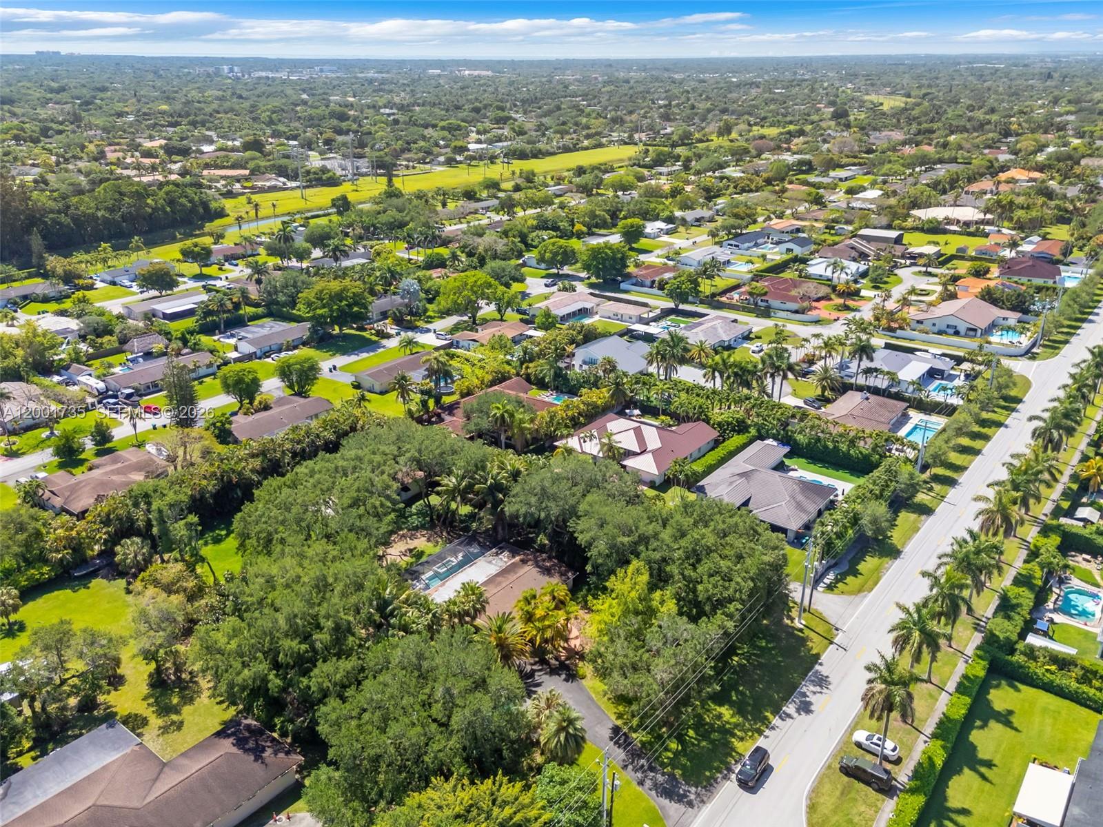 An aerial view shows a suburban neighborhood with houses, swimming pools, and lush green trees — 11401 SW 102nd Ave, Miami FL 33176, MIAMI, FL