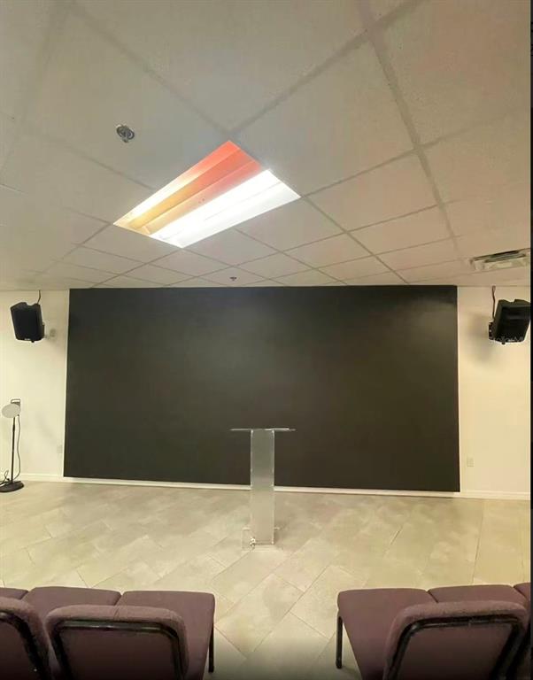 A room with a large black wall, a clear podium, and rows of purple chairs — 7075 KINGSPOINTE PARKWAY UNIT 9, ORLANDO, FL