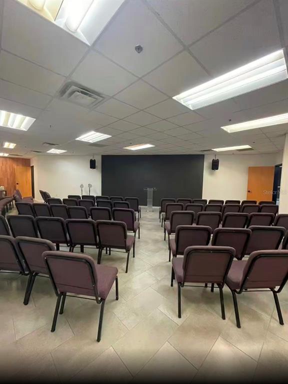 A room with rows of purple chairs facing a dark wall and a clear podium — 7075 KINGSPOINTE PARKWAY UNIT 9, ORLANDO, FL