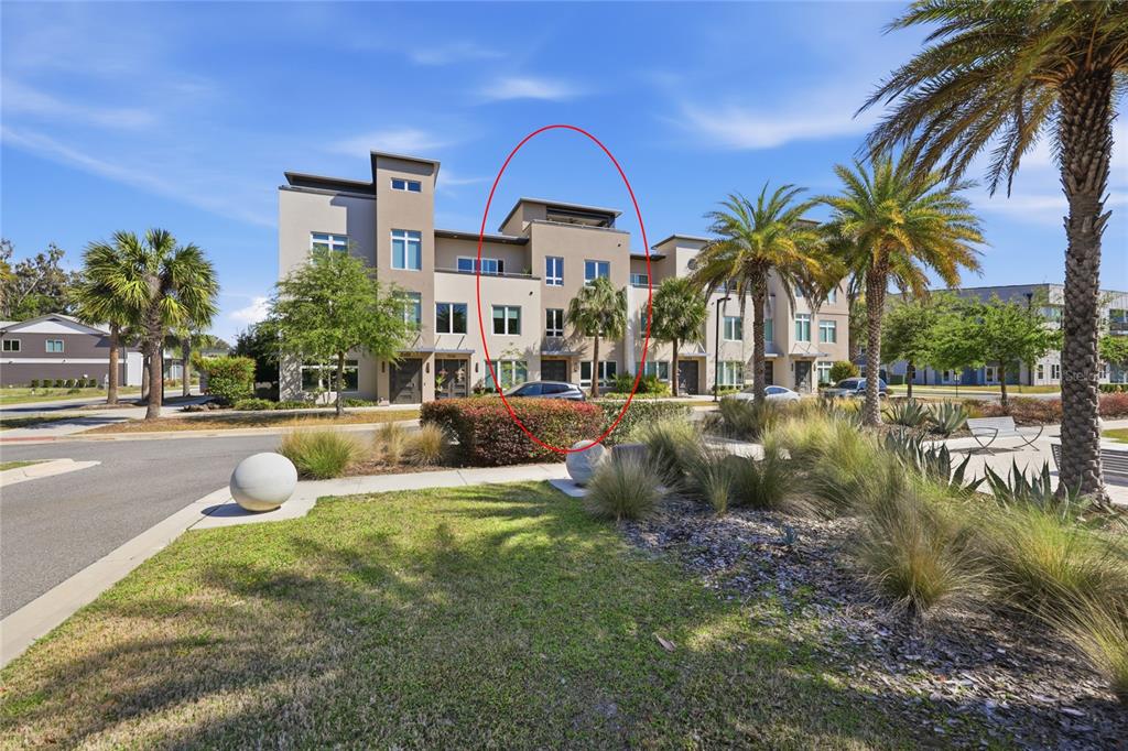 A three-story townhouse exterior with a rooftop terrace and a car parked in front — 5016 SW 34TH PLACE, GAINESVILLE, FL