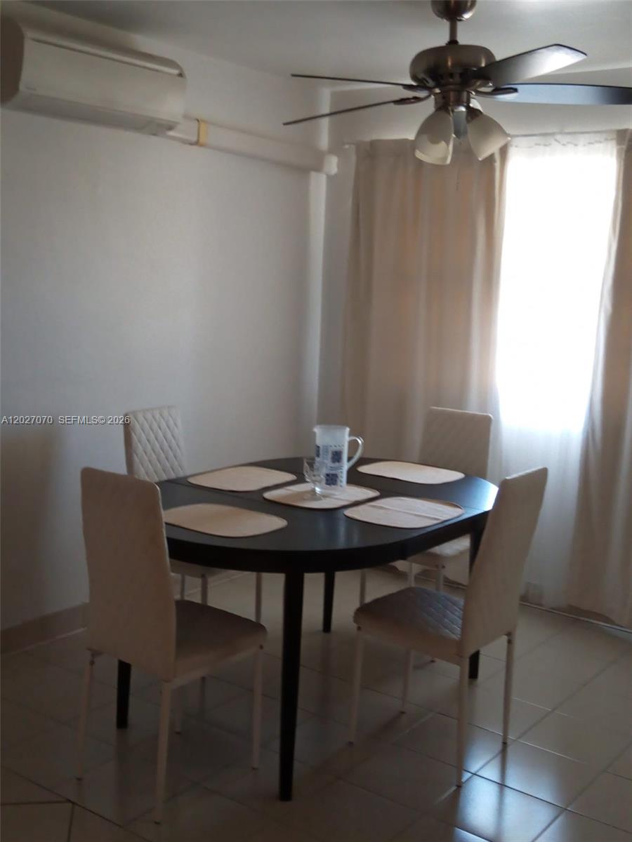A dining area features a dark oval table with four chairs under a ceiling fan — 1110 N 16 Ave # 1, Hollywood FL 33020, HOLLYWOOD, FL