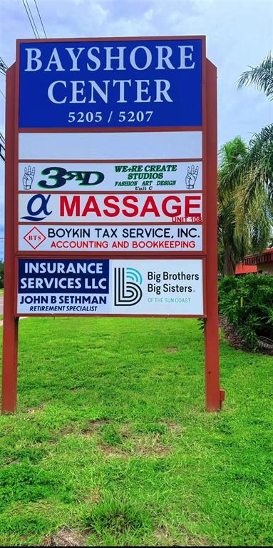 A tall, rectangular sign for Bayshore Center stands in a grassy area with palm trees — 5207 26TH STREET W, BRADENTON, FL