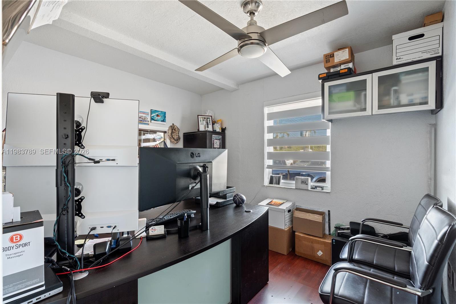 A home office features a dark desk, dual monitors, two black chairs, and a ceiling fan — 8800 NW 27th Ave # A, Miami FL 33147, MIAMI, FL