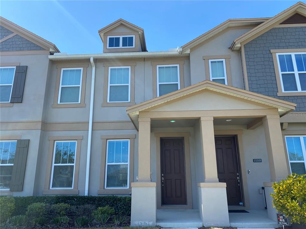 A kitchen features dark wood cabinets, granite countertops, a center island, and stainless steel appliances — 15555 HONEYBELL DRIVE, WINTER GARDEN, FL