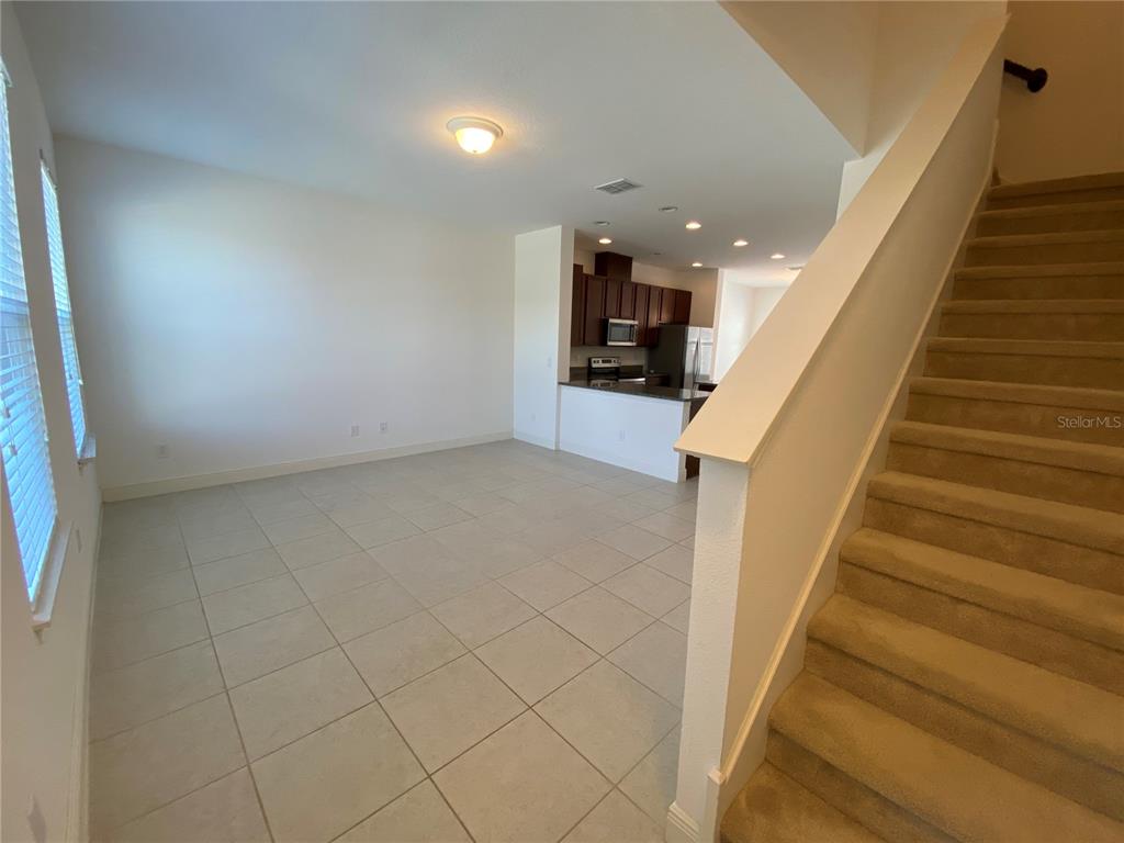 A kitchen features dark wood cabinets, granite countertops, stainless steel appliances, and a center island — 15555 HONEYBELL DRIVE, WINTER GARDEN, FL