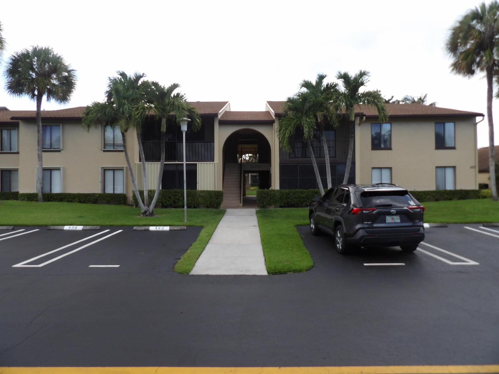 A two-story apartment building with a central arched entryway and palm trees in front — 623 Sea Pine Way # D2, FL 33415, FL
