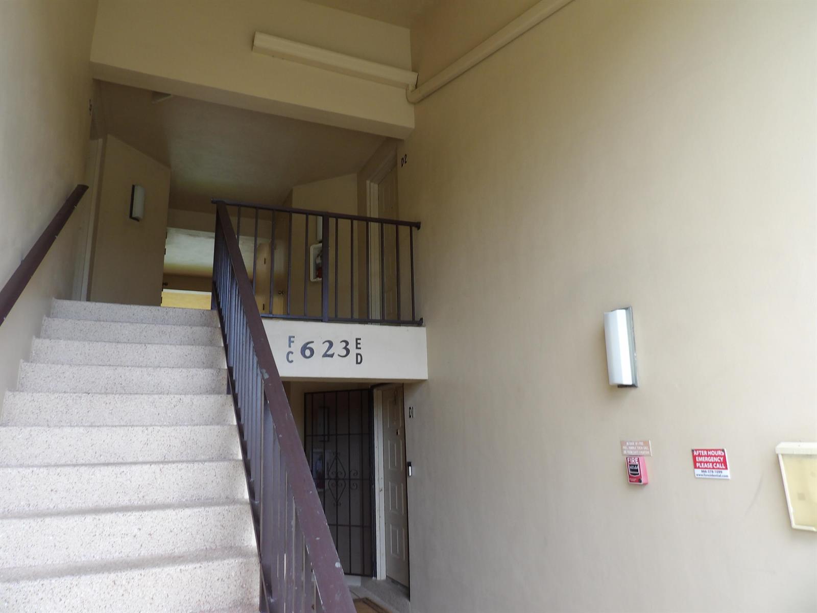 A concrete staircase leads to an upper landing with metal railings and apartment unit numbers — 623 Sea Pine Way # D2, FL 33415, FL