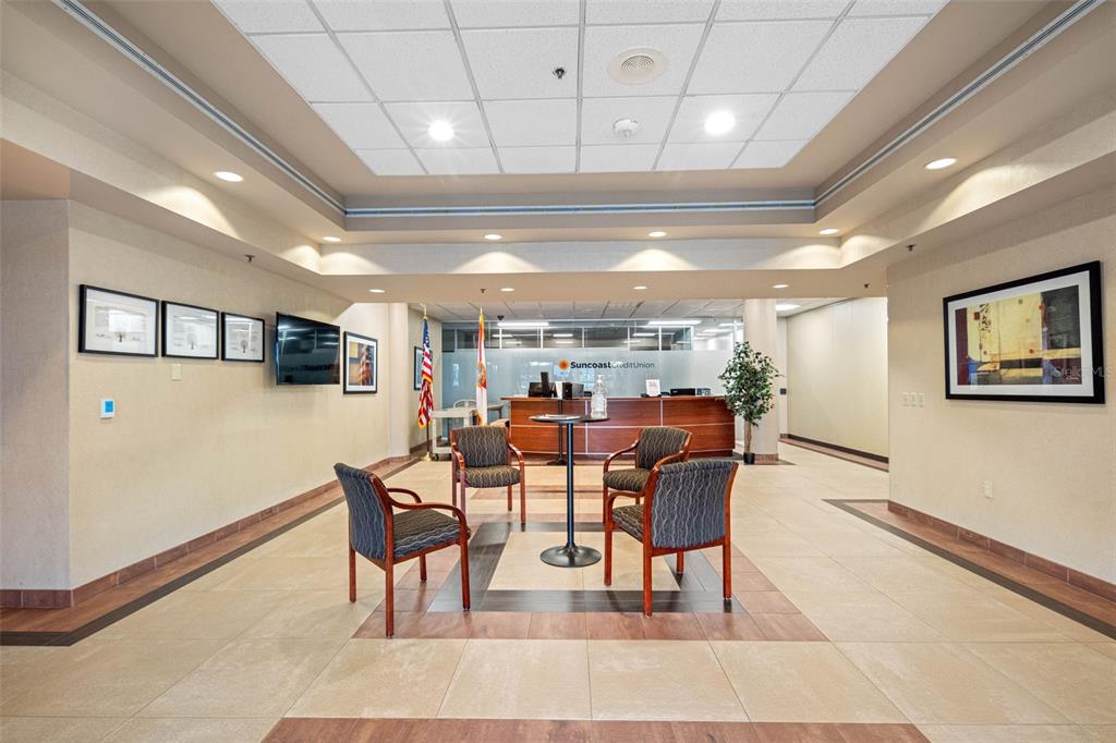A waiting area features four chairs, a small table, and a Suncoast Credit Union service desk — 6801 E HILLSBOROUGH AVENUE, TAMPA, FL