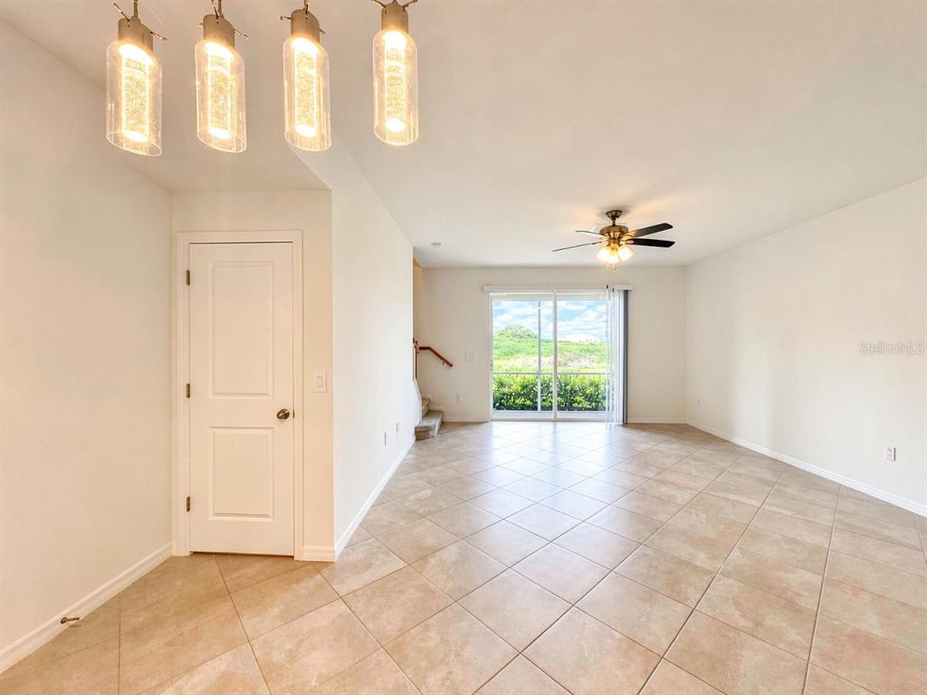 An open-concept living area features tile flooring, a ceiling fan, and sliding glass doors — 2963 CITRUS STREET, NAPLES, FL