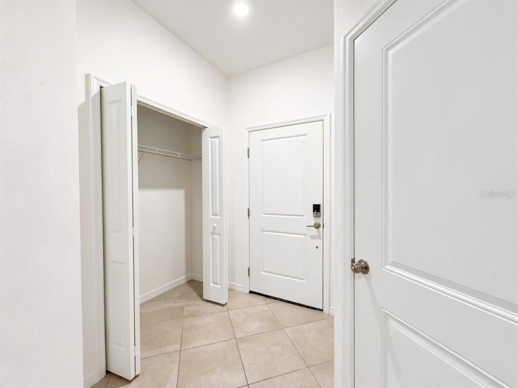 An entryway features a tiled floor, a closet with bi-fold doors, and a front door — 2963 CITRUS STREET, NAPLES, FL