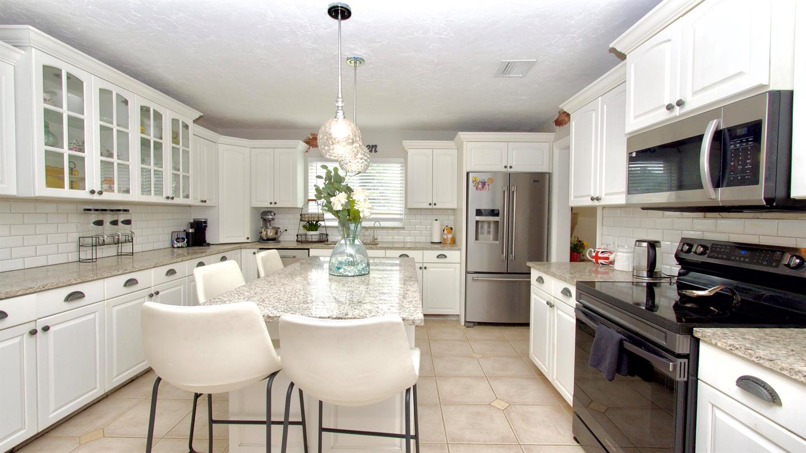 A kitchen features white cabinets, granite countertops, stainless steel appliances, and a central island — 5191 SW 109th Avenue, Davie FL 33328, DAVIE, FL