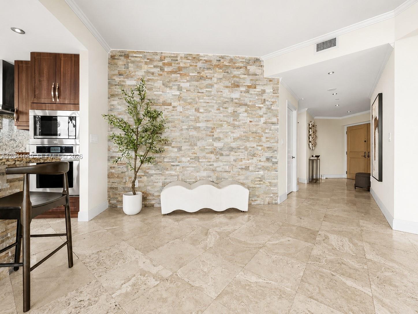 A kitchen area features a stone accent wall, a white bench, and tile flooring — 2645 S Bayshore Dr # 304, Miami FL 33133, MIAMI, FL