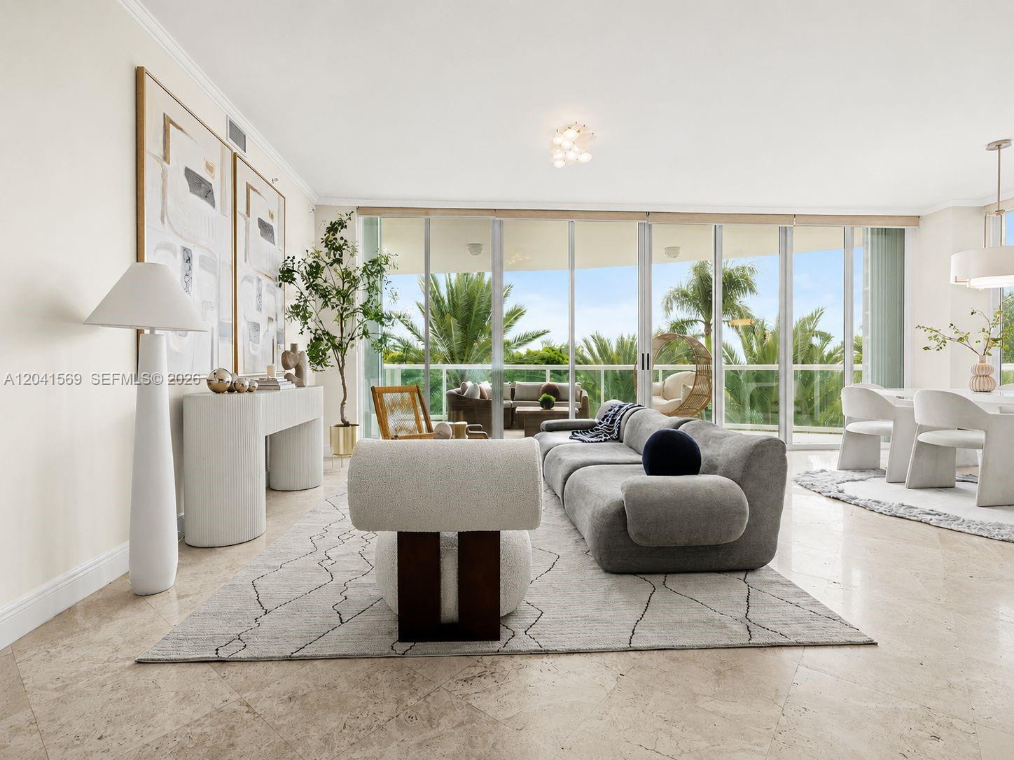 A modern living room features a grey sofa, white accent chair, and floor-to-ceiling windows — 2645 S Bayshore Dr # 304, Miami FL 33133, MIAMI, FL