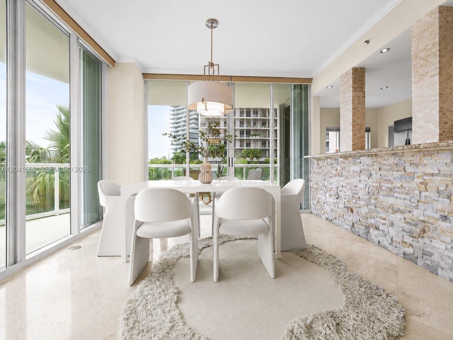 A dining room features a white table, four chairs, a shaggy rug, and stone-tiled walls — 2645 S Bayshore Dr # 304, Miami FL 33133, MIAMI, FL