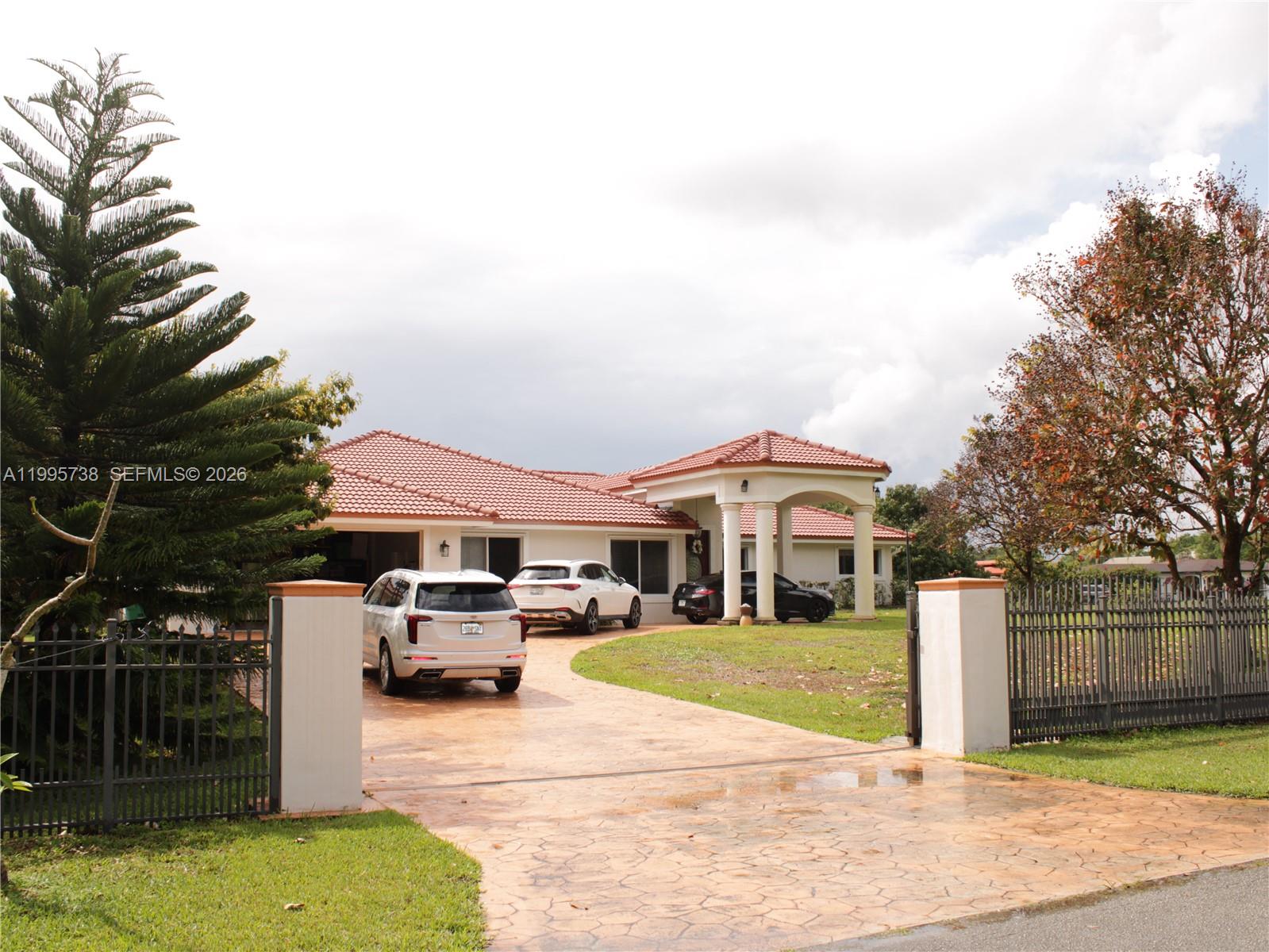A single-story house with a red tile roof and a circular driveway behind a gate — 4931 SW 167th Ave, Southwest Ranches FL 33331, SOUTHWEST RANCHES, FL