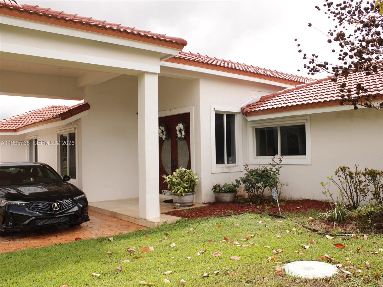 A white house with a red tile roof features a covered entryway and a driveway — 4931 SW 167th Ave, Southwest Ranches FL 33331, SOUTHWEST RANCHES, FL