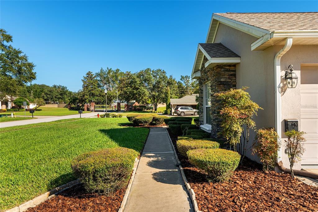 A concrete walkway leads past a landscaped front yard toward the side of a house — 3865 SE 52ND AVENUE, OCALA, FL