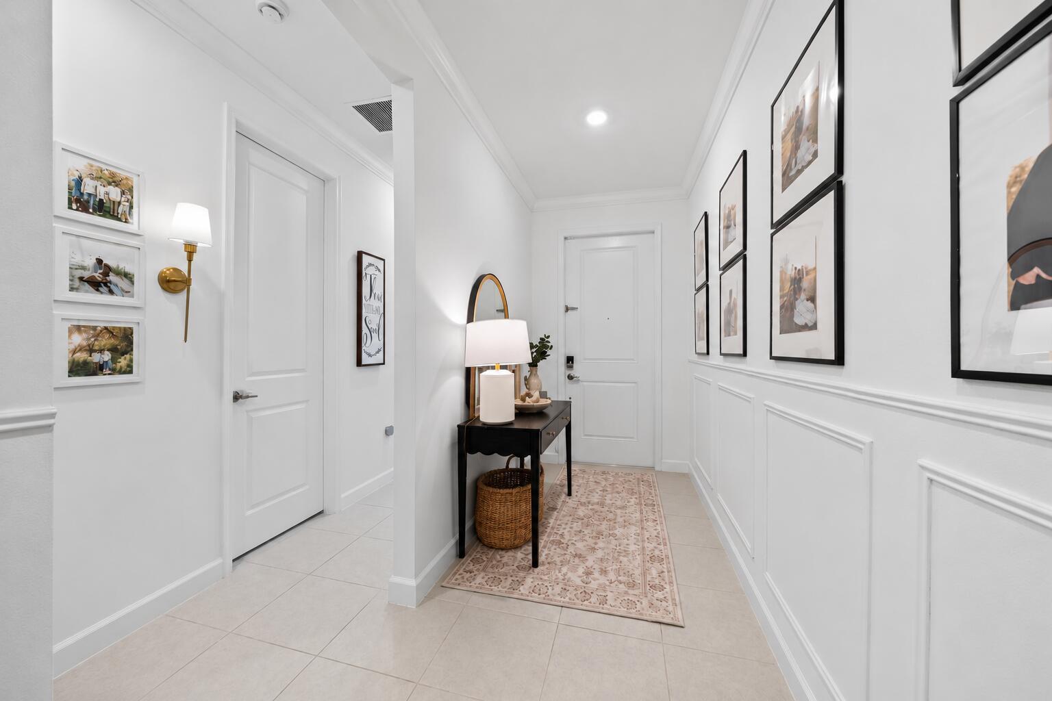 A bright entryway features white walls with wainscoting, a console table, and framed wall art — PALM BAY, FL
