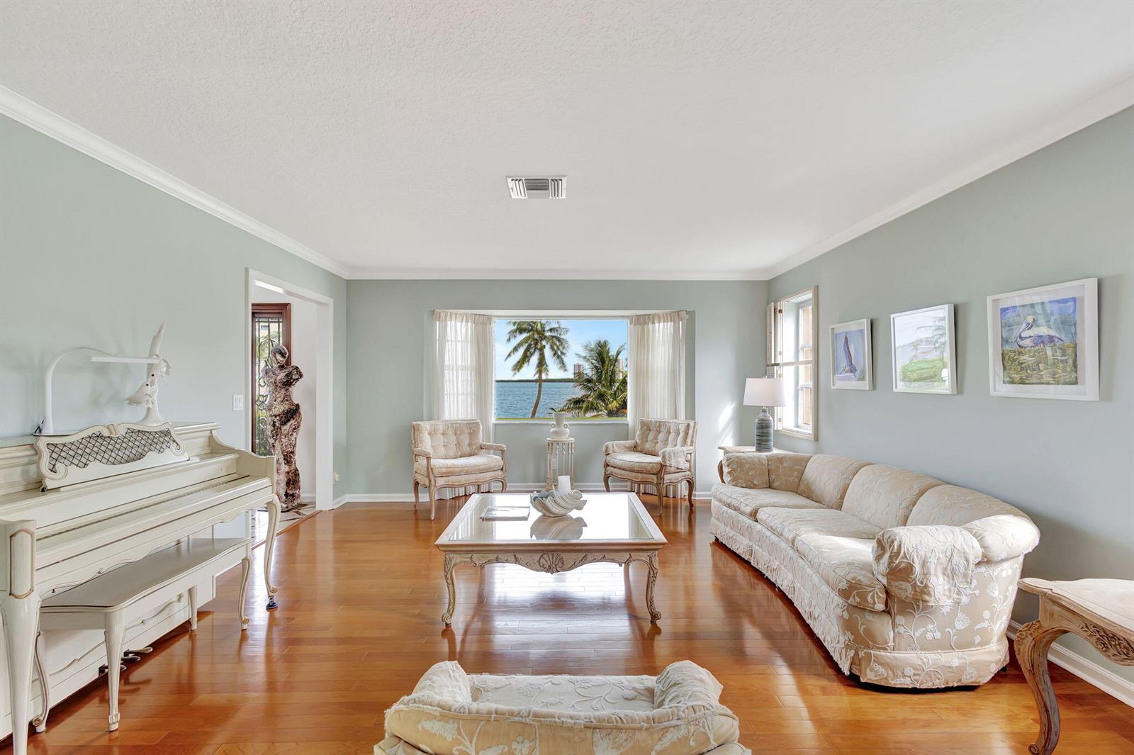 A living room features a white piano, a beige sofa, and a large window view — 1141 Pine Point Road, West Palm Beach FL 33404, WEST PALM BEACH, FL