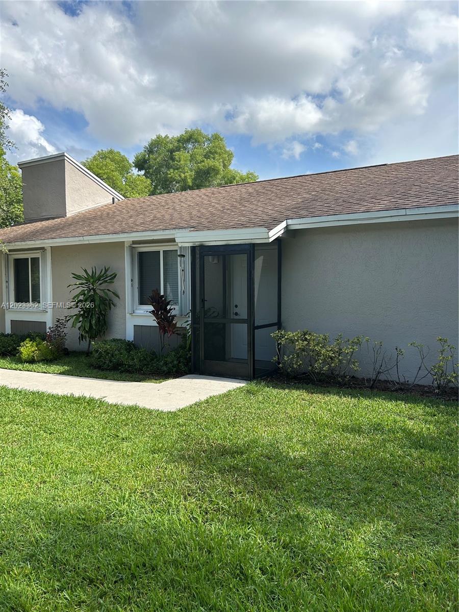 A single-story house exterior features a screened-in entryway, light-colored stucco walls, and a shingled roof — 578 Woodgate Cir, Sunrise FL 33326, SUNRISE, FL