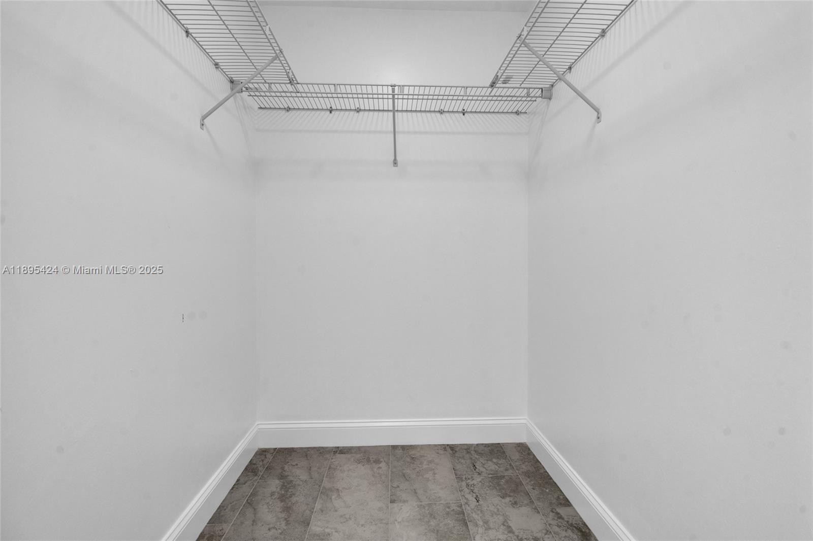 This walk-in closet features white walls, tile flooring, and wire shelving — 2508 Park Rd, Lehigh Acres FL 33971, LEHIGH ACRES, FL