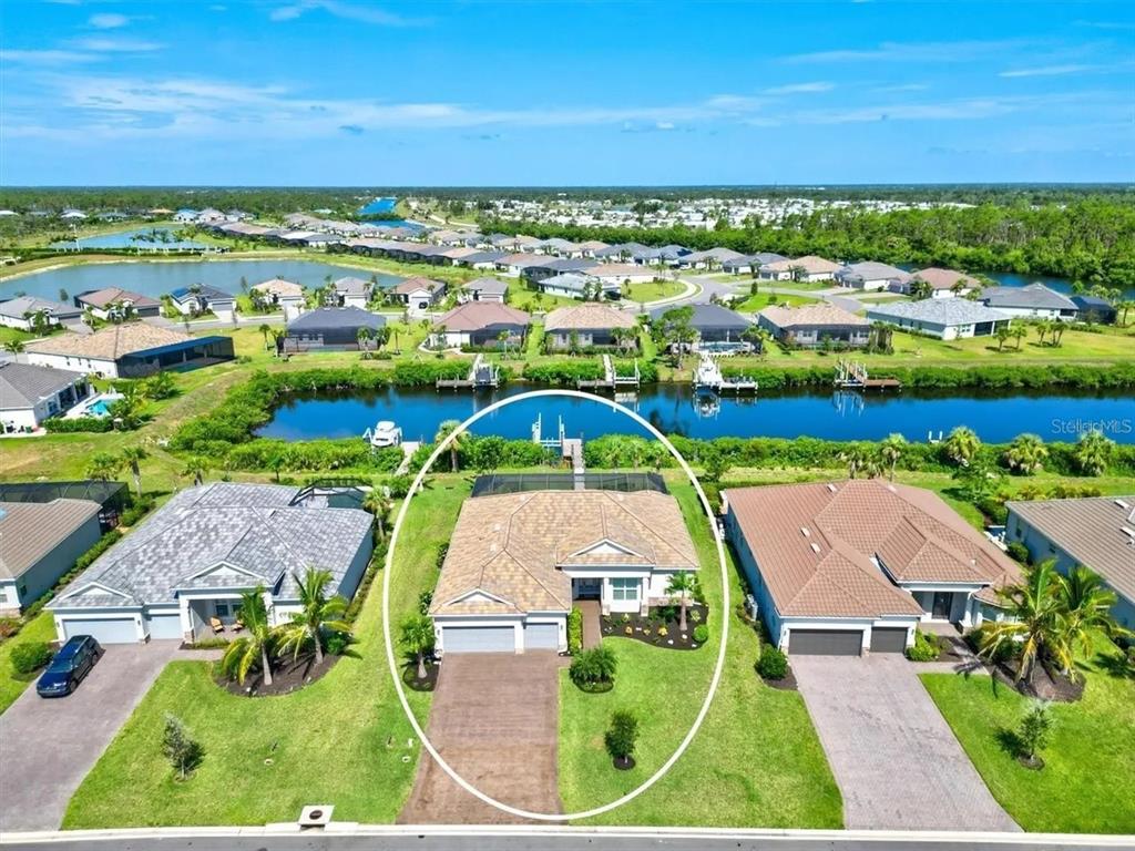 An aerial view shows a single-family house with a screened pool and private boat dock — 15024 SPANISH POINT DRIVE, PORT CHARLOTTE, FL