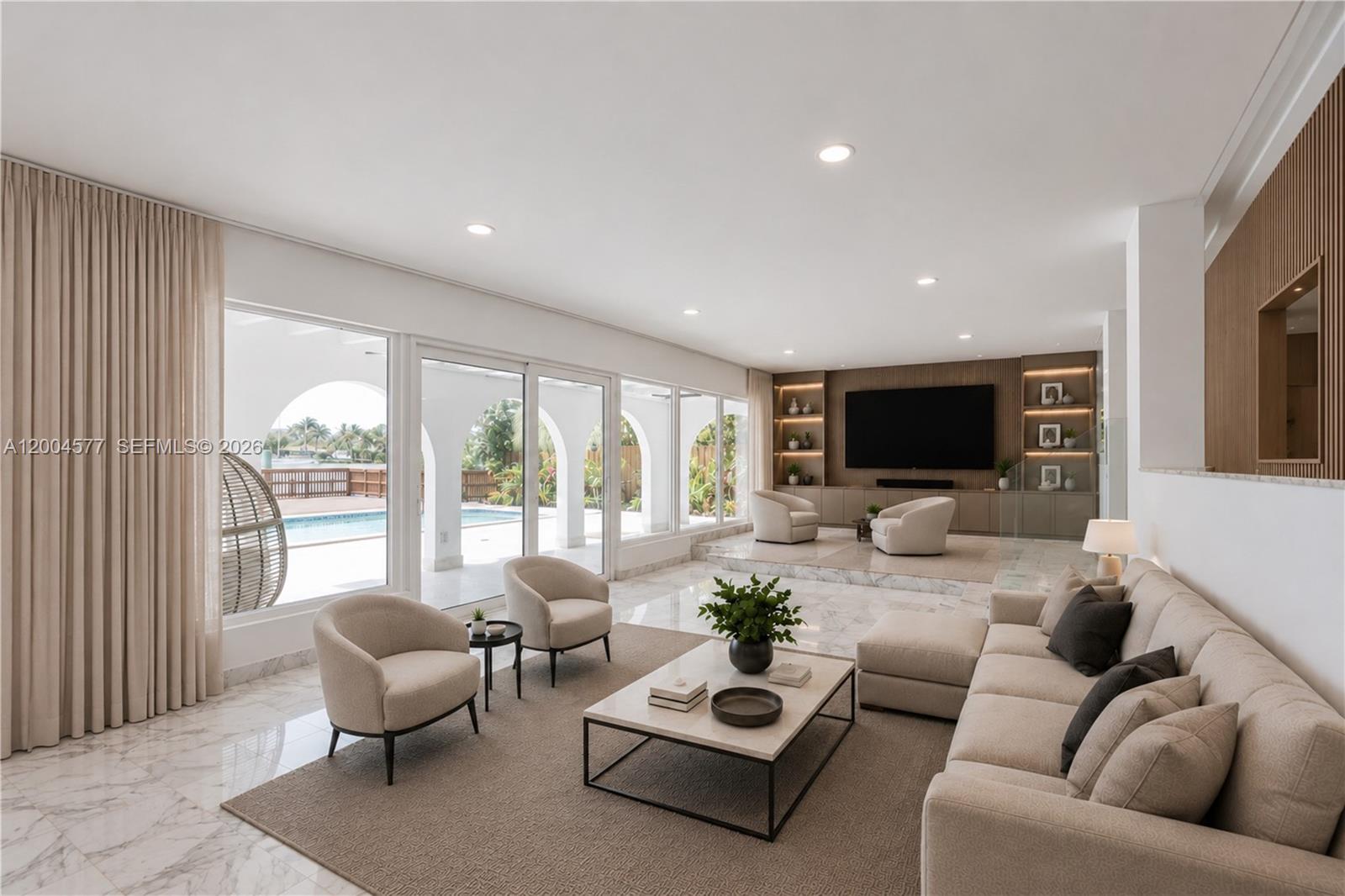 A spacious living room features marble floors, a sunken seating area, and large glass doors — 1690 Daytonia Rd, Miami Beach FL 33141, MIAMI BEACH, FL