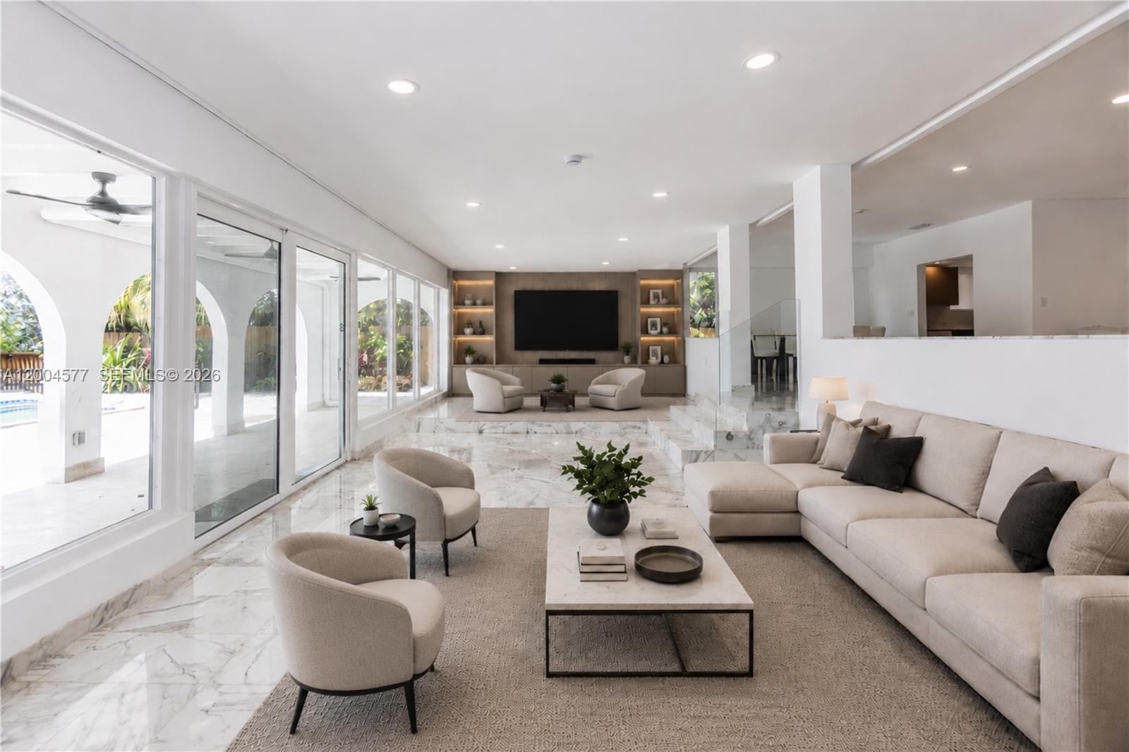 A spacious, modern living room features marble floors, a large sectional, and floor-to-ceiling glass doors — 1690 Daytonia Rd, Miami Beach FL 33141, MIAMI BEACH, FL