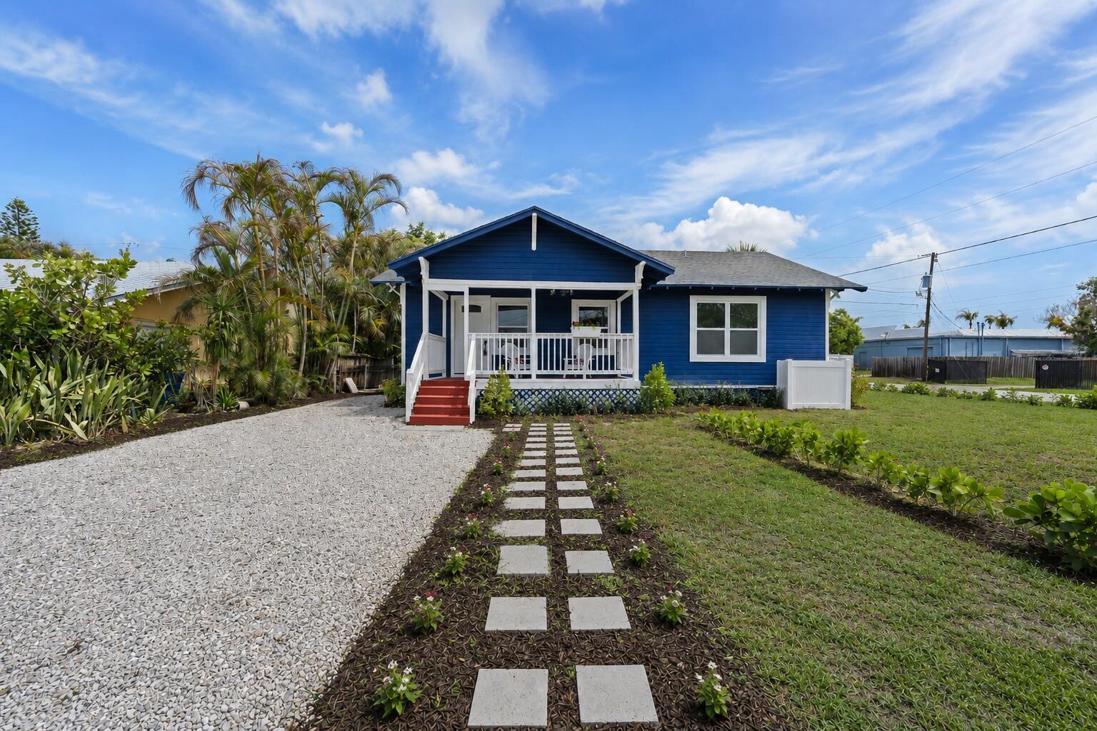 A blue house with a white porch, red stairs, and a stone walkway — 1566 NW 9th Avenue, Stuart FL 34994, STUART, FL